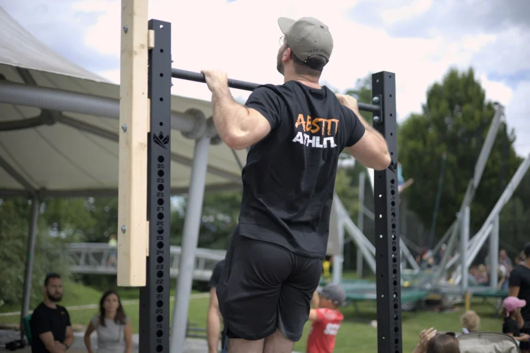 Eine Person macht in einem Park Klimmzüge.